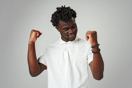 Young Man in White Shirt Celebrating Personal Victory With Fist Pump