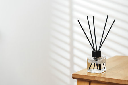 Modern Reed Diffuser on Wooden Table in Minimalist Interior During Daytimeの写真素材