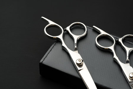 Hairdressing scissors with case on a black background