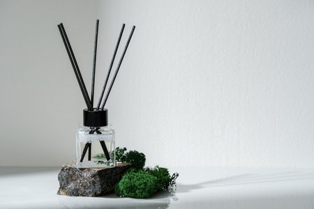 Elegant Aroma Diffuser With Black Reeds on a Granite Base Next to Moss Decorの写真素材