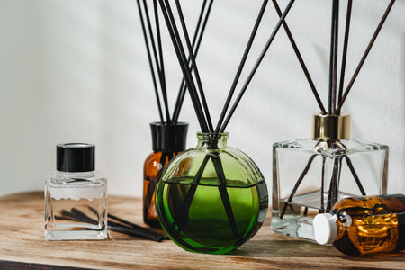 A Collection of Aromatic Reed Diffusers on a Wooden Table Against a Neutral Background