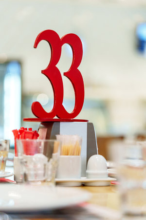 Bright Red Table Number 33 Display in a Busy Restaurant During Lunchtimeの写真素材
