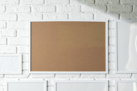 Varied Sized Photo Frames Displayed on a White Brick Wall