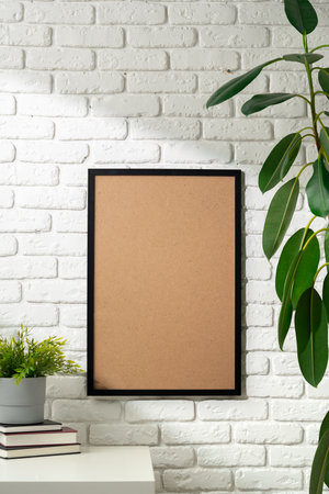 Blank Photo Frame on White Brick Wall With Houseplants and Books
