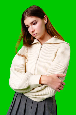 Young Woman Contemplating Deeply Against a Vibrant Green Backgroundの写真素材