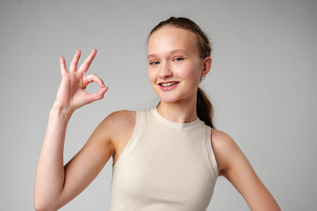 Young Girl Giving Thumbs Up Sign in studioの写真素材