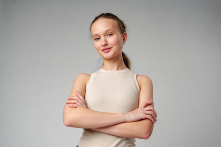 Girl in Beige Tank Top and Grey Jeans on gray backgroundの写真素材