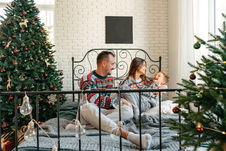 Happy family near fir-tree in bedroom, Christmas celebration at homeの写真素材