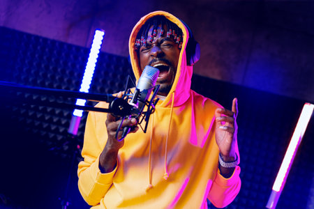 Young African performer recording his new track in recording studioの写真素材