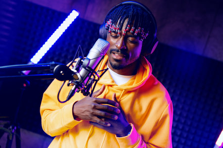 Young African performer recording his new track in recording studio