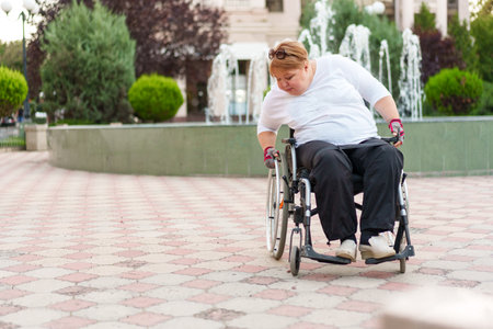 Mature woman with disability sitting in wheelchair outdoors