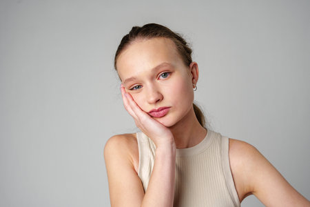 Young Woman Grimacing in Displeasure Against a Neutral Backgroundの写真素材