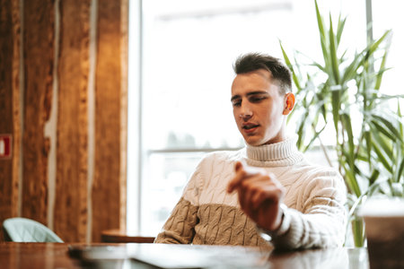Man Sitting at Table With Laptop Computerの写真素材