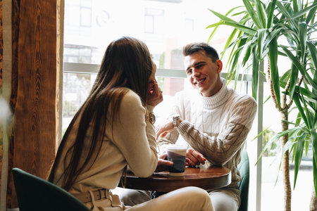 Man and Woman Sitting at Table Talkingの写真素材