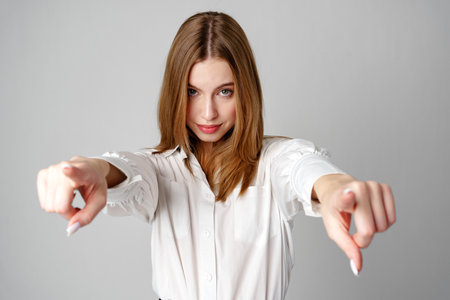 Young Woman in White Shirt Gesturing Come Here With Both Handsの写真素材