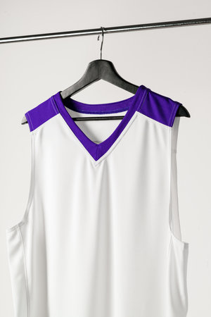 White basketball jersey hanging against white background