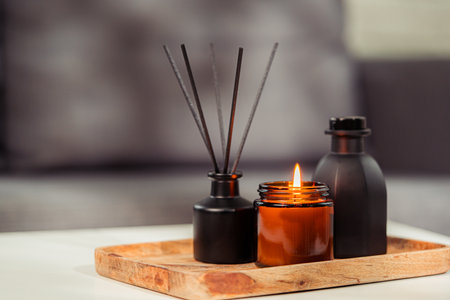 Aromatic reed freshener and candle on table in roomの写真素材