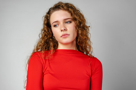 Young Woman With Curly Hair Expressing Concernの写真素材