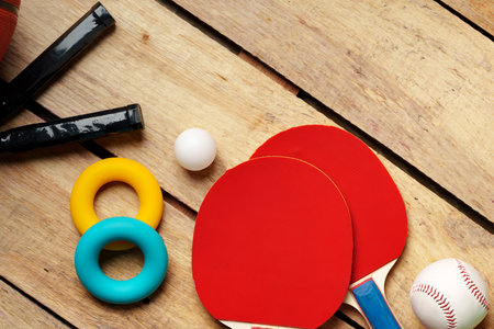 Different sports equipment on wooden background top viewの写真素材
