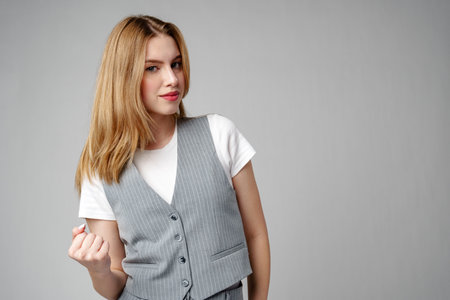 Jubilant Young Woman Celebrating a Victory With a Raised Fist in Studioの写真素材