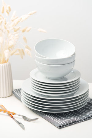 Stylish table setting with white dishware on white tableclothの写真素材