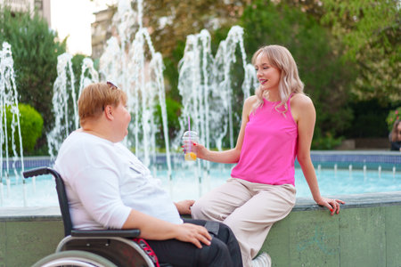 Young daughter taking care of her mother with disability sitting in wheelchairの写真素材
