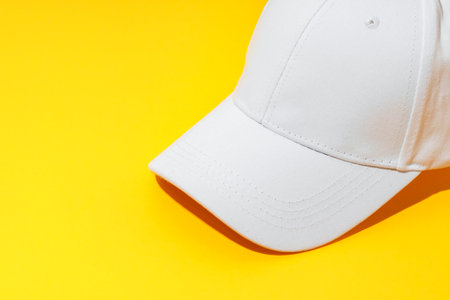 Baseball hat against yellow background in studioの写真素材