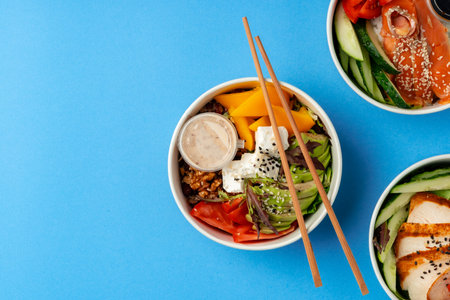 Different poke bowls on blue background top viewの写真素材