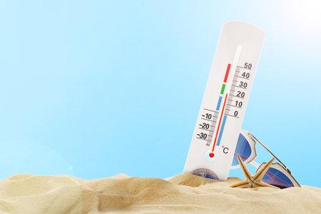 White Thermometer In Sand With Sunglasses And Starfish On Blue Sky Day