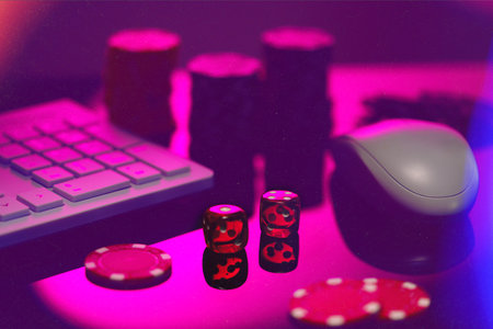 Red Dice on a Pink Surface With a Computer Keyboard and Mouseの写真素材