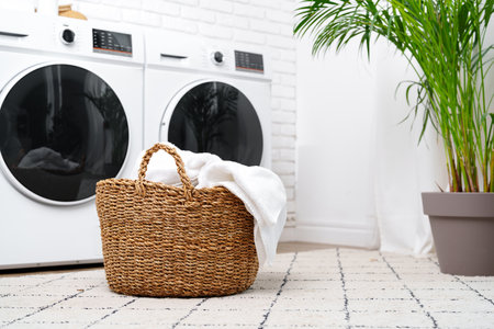 Laundry Basket With White Towels Near Modern Washers In A Modern Homeの写真素材