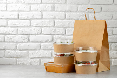 Take out food in boxes and craft bag against brick backgroundの写真素材