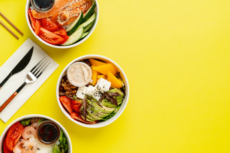 Top view of fresh poke bowls on yellow backgroundの写真素材