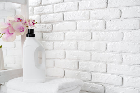 Laundry Detergent Bottles and Stacked Towels On Top of a Washing Machineの写真素材