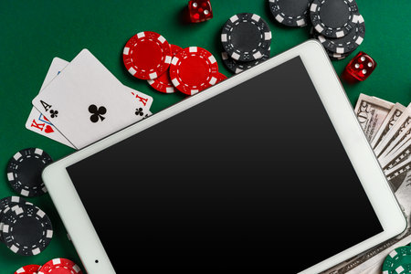 Online Casino Gambling With Tablet, Cards, Chips, and Dice On Green Feltの写真素材