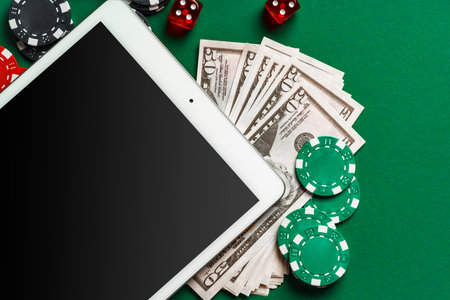 Online Casino Gambling With Tablet, Cards, Chips, and Dice On Green Felt