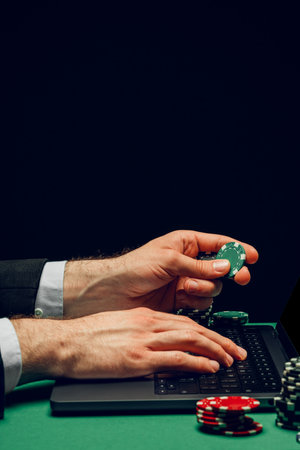 Person Playing Online Poker Game With Laptop and Chipsの写真素材