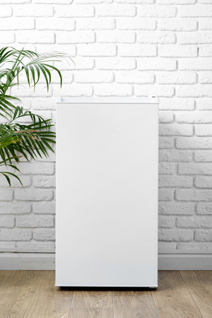 White Refrigerator Against White Brick Wallの写真素材
