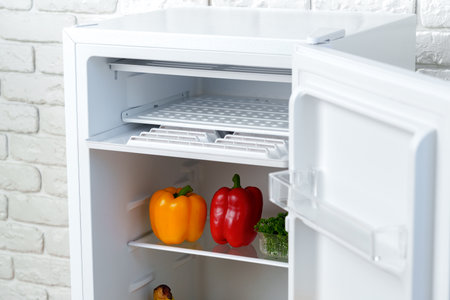 Open Refrigerator Door Showing Fresh Produce Insideの写真素材