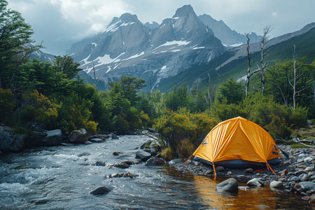 Bright Orange Tent Beside Clear Stream in Mountainous Wilderness During Daylight Hoursの素材