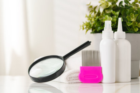 Lice treatment product next to a nit comb and magnifying glassの写真素材