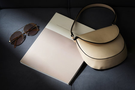 Beige Leather Handbag and Sunglasses on Grey Couchの写真素材