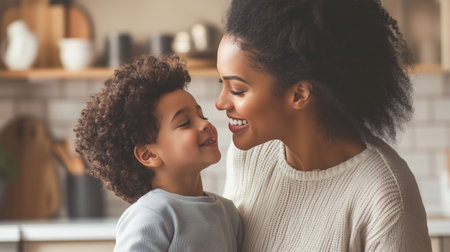 A mother and her son share a joyful moment at home in the kitchen during a sunny afternoonの素材