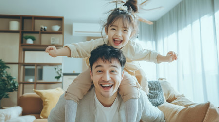 A joyful father gives his daughter a piggyback ride indoors, filled with laughter and warmth during a sunny afternoonの素材