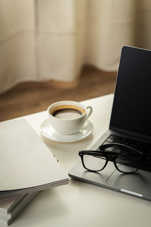 Modern Workspace With Laptop, Glasses, and Magazinesの写真素材