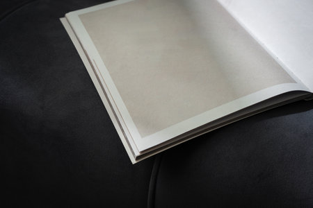 Stack of Magazines on a Black Leather Couch in Soft Light