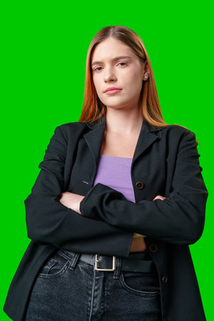 Young Woman Wearing Black Blazer and Purple Top Against Green Screenの写真素材