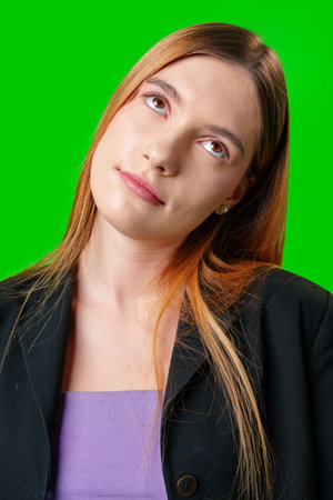 Young Woman Wearing Black Blazer and Purple Top Against Green Screenの写真素材