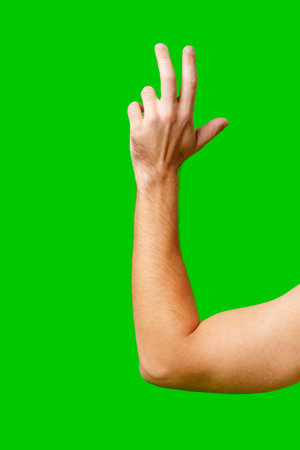 Hand Gesture Above Arm Against Bright Green Backgroundの写真素材