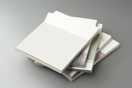A stack of blank notebooks arranged neatly on a simple grey backgroundの写真素材